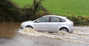A car makes it's way through the flooded road outside Clonakilty, Co. Cork yesterday. Photo: Billy macGill