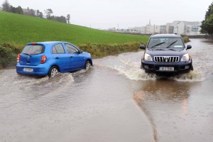 Two cars carefully pass each other on a flooded road outside Clonakilty, Co. Cork yesterday. Photo: Billy macGill