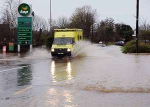 An ambulance makes it's way through the flooded road at Ballinscarthy, West Cork yesterday. Photo: Billy macGill